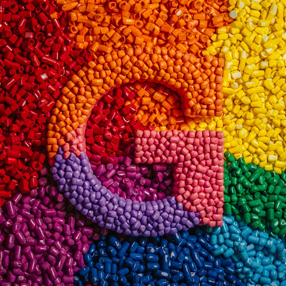 Grânulos coloridos de polímero formando o G da Gold Brasil